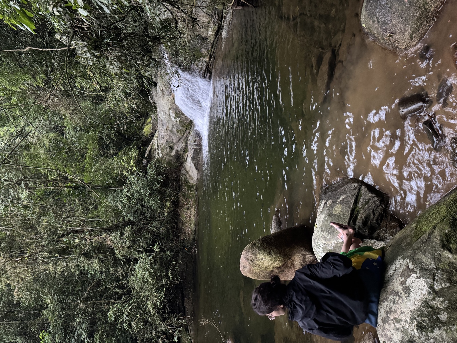 Wasserfall im Regenwald mit Person am Ufer